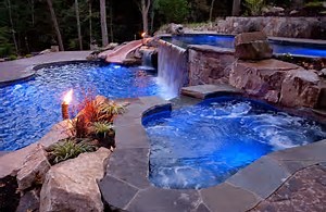 An evening lit pool and hot tub.